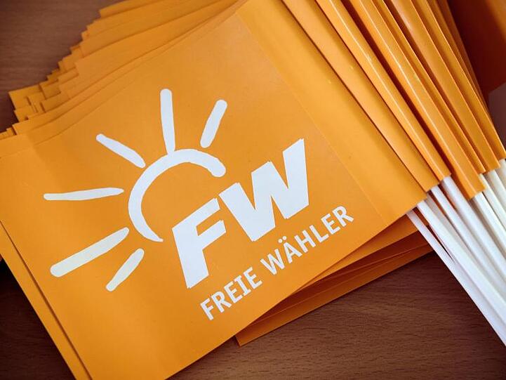 Bei der Landesversammlung der Freien Wähler sind Fähnchen mit dem Logo der Partei auf einem Tisch zu sehen. Foto: Nicolas Armer/Archiv