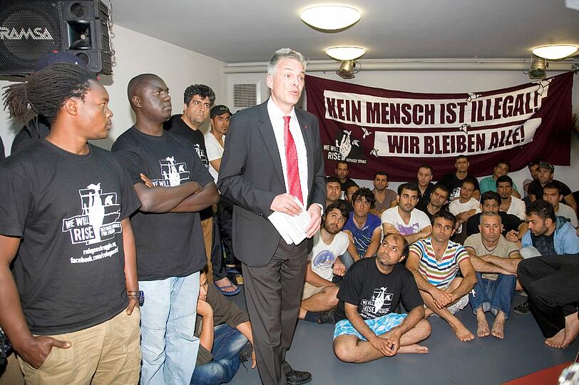 m Partykeller des DGB-Hauses verhandelt DGB-Boss Matthias Jena mit den Flüchtlingen. Vier Dolmetscher übersetzen (Englisch, Französisch, Urdu, Farsi).