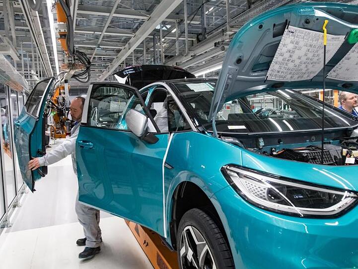 Mitarbeiter von Volkswagen komplettieren ein Auto. Foto: Hendrik Schmidt/dpa-Zentralbild/ZB/Archivbild