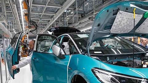 Mitarbeiter von Volkswagen komplettieren ein Auto. Foto: Hendrik Schmidt/dpa-Zentralbild/ZB/Archivbild