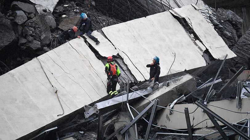 Rettungsarbeiten unter den Trümmern der eingestürzten Morandi Autobahnbrücke.