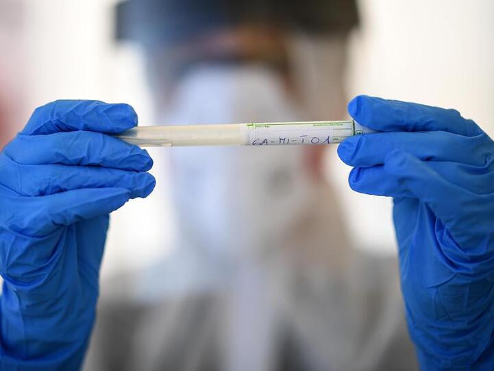 Ein Mitarbeiter vom Gesundheitsamt hältt ein Test-Röhrchen. Foto: Britta Pedersen/dpa-Zentralbild/dpa/Symbolbild