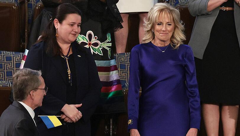 First Lady Jill Biden in einem blauen Kleid mit Sonnenblumenstickerei am Ärmel.
