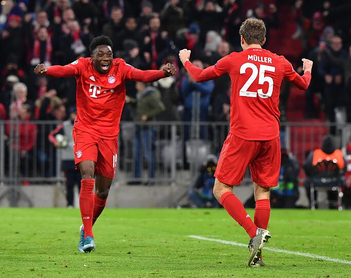 Alphonso Davies (l.) und Thomas Müller feiern das 2:1 des FC Bayern gegen Tottenham Hotspur in der Champions League.