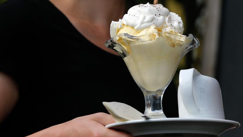 Eine Kellnerin serviert in einer Gaststätte einen Eisbecher. In Deutschland bekommen viele Beschäftigte nicht den Stundenlohn, der ihnen zusteht. Eine Kellnerin serviert in einer Gaststätte einen Eisbecher. In Deutschland bekommen viele Beschäftigte nicht den Stundenlohn, der ihnen zusteht.