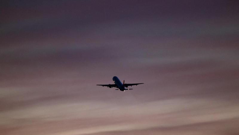 Ein Flugzeug startet in den Abendhimmel.
