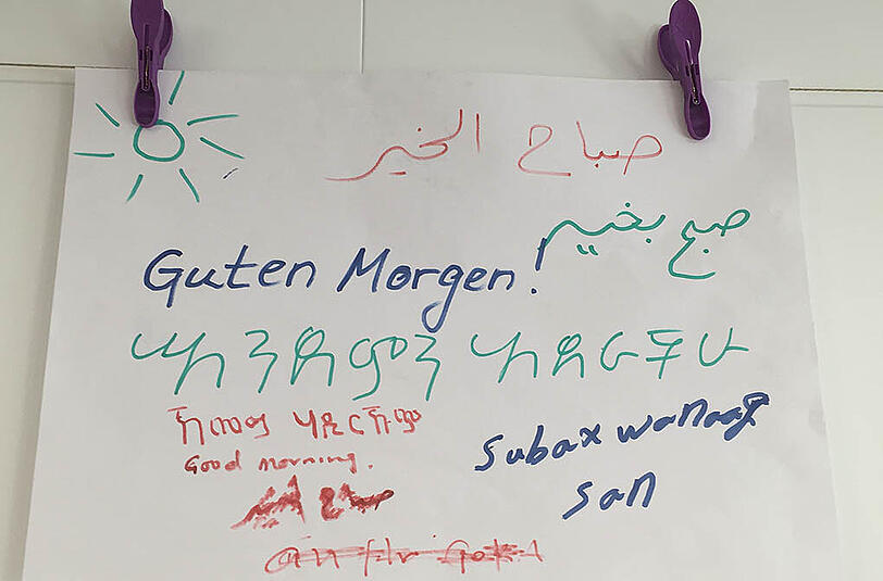 &bdquo;Guten Morgen&ldquo; erklärt auf Englisch, Arabisch, Dari (Afghanistan), Amharisch (Äthiopien) und Somali &ndash; eine Übung aus dem Deutschunterricht.