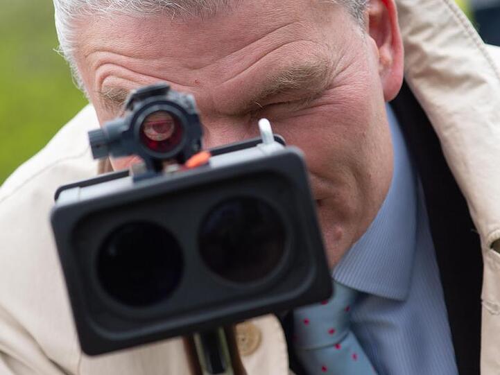 Sachsen-Anhalts Innenminister Holger Stahlknecht (CDU) schaut durch eine Laserpistole zur Geschwindigkeitsmessung.