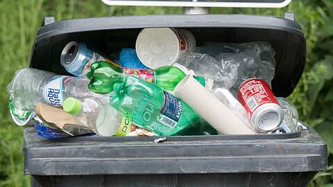 Plastikflaschen liegen in einer überfüllten Mülltonne. Foto: Armin Weigel