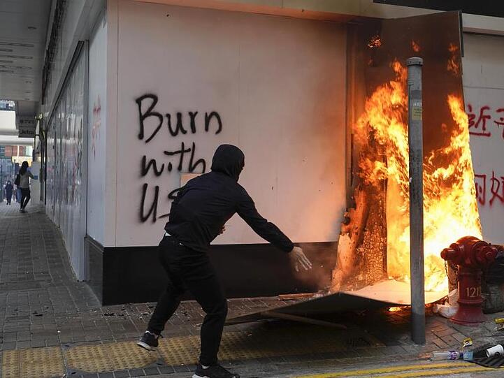 Ein Demonstrant setzt außerhalb der Bank of China im Central District von Hongkong Kartons in Brand.