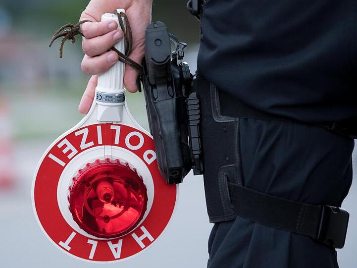 Ein Polizist hält eine Kelle mit der Aufschrift "Halt. Polizei" in der Hand. Foto: Sven Hoppe/dpa/Symbolbild