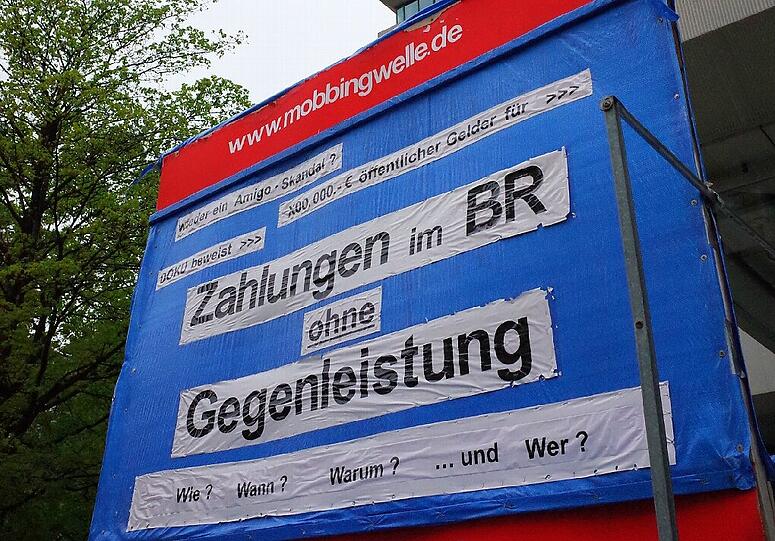 Vor dem Hochhaus des Bayerischen Rundfunks an der Arnulfstraße steht ein Plakat mit Angriffen gegen den Sender.
