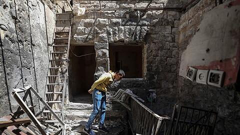 Ein Palästinenser inspiziert ein beschädigtes Haus nach einer Razzia der israelischen Streitkräfte.
