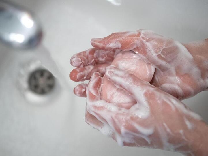 Eine Person wäscht sich die Hände mit fließendem Wasser und Seife. Foto: Marijan Murat/dpa/Archivbild