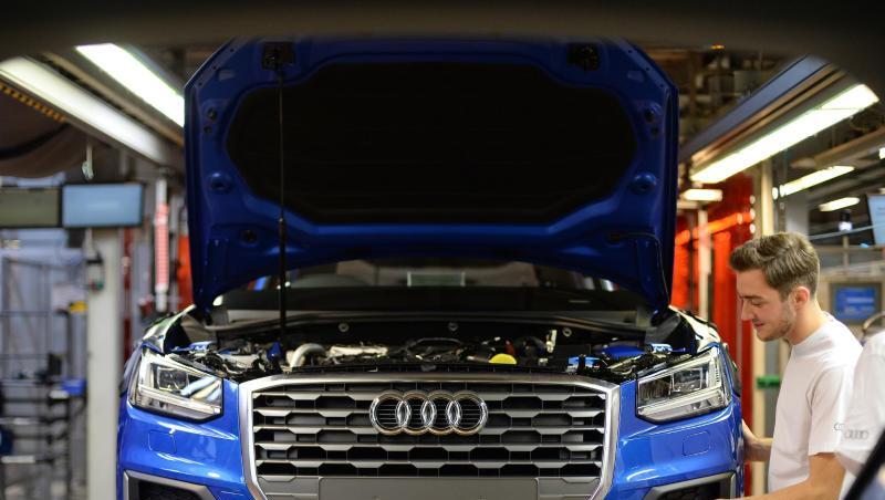 Ein Mitarbeiter bringt an einem Fließband im Audi-Werk das Frontende an einem Audi an. Foto: dpa Ein Mitarbeiter bringt an einem Fließband im Audi-Werk das Frontende an einem Audi an. Foto: dpa