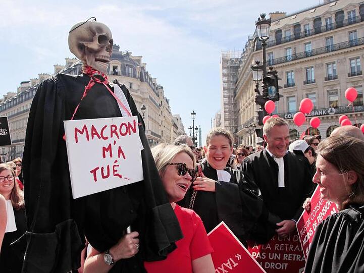 Protest in Paris: Ein Skelett in einer Richterrobe und einem Schild mit der Aufschrift "Macron hat mich getötet".