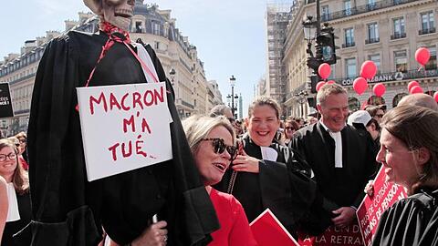 Protest in Paris: Ein Skelett in einer Richterrobe und einem Schild mit der Aufschrift "Macron hat mich getötet".