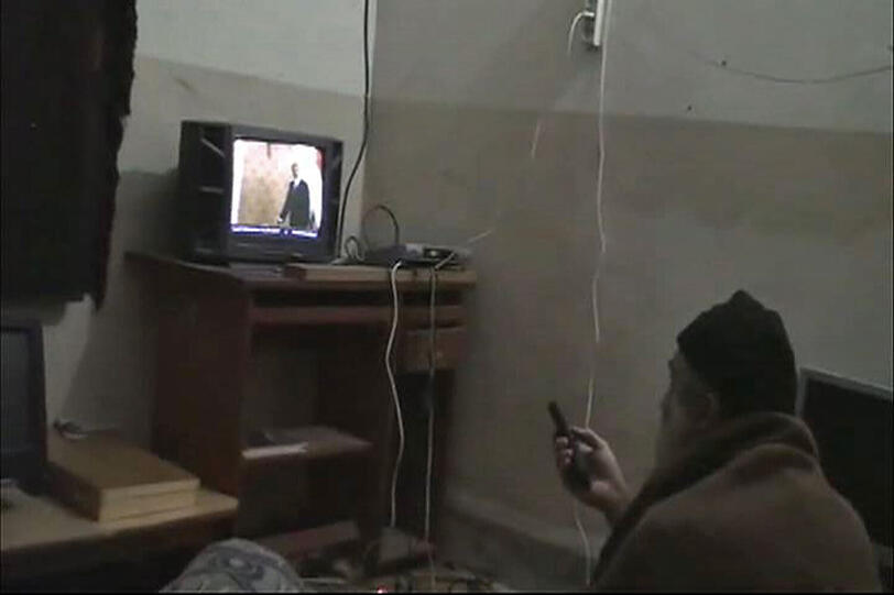 Die Szene aus einem vom Pentagon freigegebenen Video zeigt Osama bin Laden vor einem Fernseher mit einer Fernbedienung in der Hand.