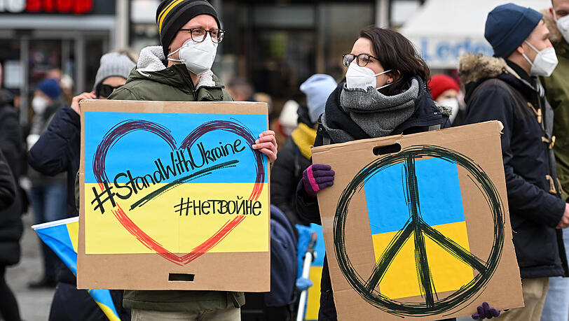 Demonstranten halten am Samstag Plakate mit der Aufschrift "#StandWithUkraine" bei einer Demonstration auf dem Odeonsplatz gegen Russlands Angriff auf die Ukraine.