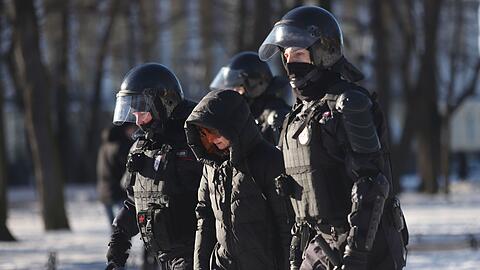Polizeibeamte nehmen am Sonntag eine Demonstrantin in St. Petersburg fest.