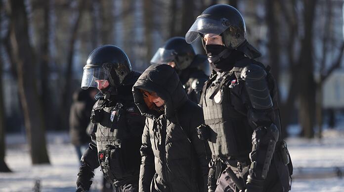 Polizeibeamte nehmen am Sonntag eine Demonstrantin in St. Petersburg fest.