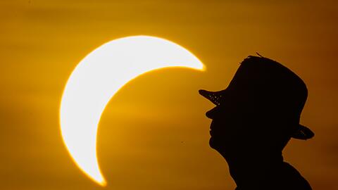 Ein Mann betrachtet die partielle Sonnenfinsternis im &ouml;stlichen Brandenburg.