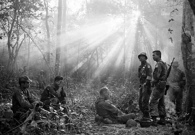 Die Sonne bricht durchs Baumdickicht bei der Stadt Binh Gia, 40 Meilen östlich von Saigon. Südvietnamesische Truppe und amerikanische Berater warten nach einer kalten, angespannten Nacht in einem Versteck auf einen Angriff der Vietcong, der nicht passiert.