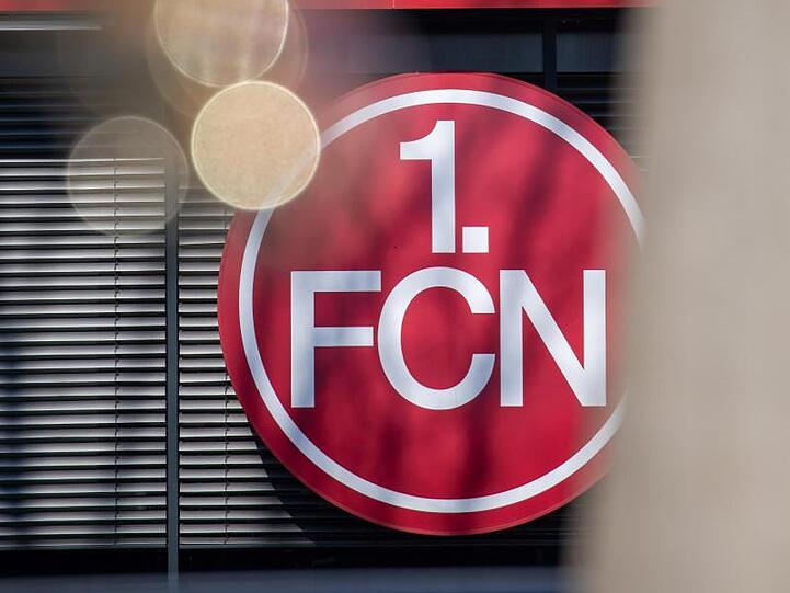 Das Logo des 1. FC Nürnberg hängt an der Geschäftsstelle. Foto: Daniel Karmann/dpa