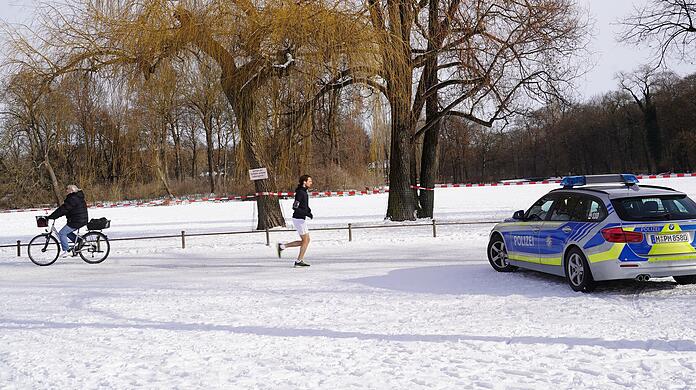 Ein Absperrband rund um den Kleinhesseloher See. Die Polizei achtet darauf, dass niemand die Eisfläche betritt.