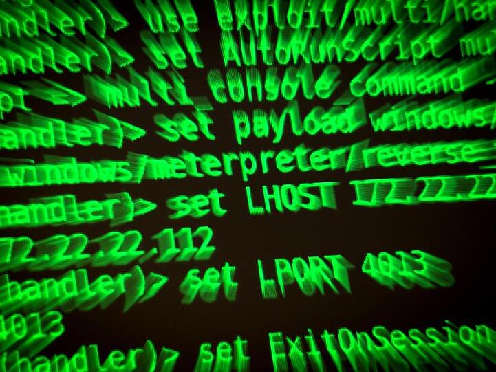 Buchstaben und Zahlen leuchten auf einem Bildschirm, auf dem ein Hackerwerkzeug läuft.