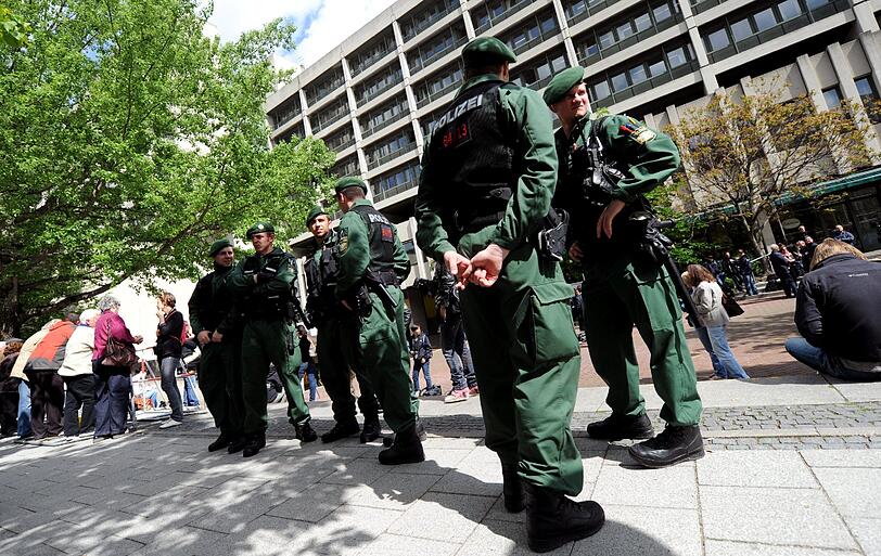 Polizisten stehen am 14.05.2013 vor dem Gerichtsgebäude in München