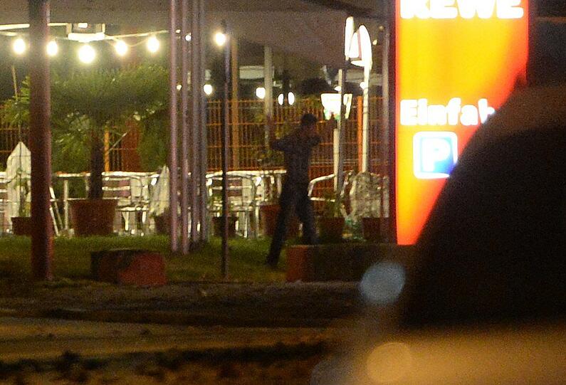 Mit erhobenen Händen kommt ein Mann auf die SEK-Beamten zu, im Hintergrund lauern Heckenschützen der Polizei. Die Beamten nehmen den Mann fest, es ist aber nicht der Täter, der sich in einem Imbiss in Freiburg veschanzt hat.
