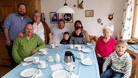 Ludwig, Anton, Karin, Georg, Xaver, Steffi, Simon, Anna und Kilian Schmid (von links) sitzen in ihrer Küche fürs Foto zusammen.