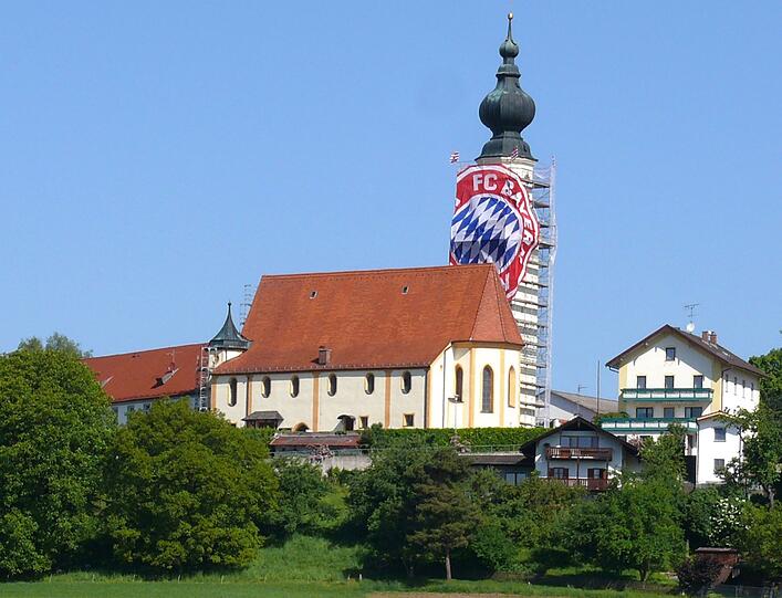 Champions League über die Stadtgrenze hinaus: Eine Bayern-München-Fahne schmückt den Kirchturm der Pfarrkirche St. Nikolaus in Höslwang (Landkreis Rosenheim).