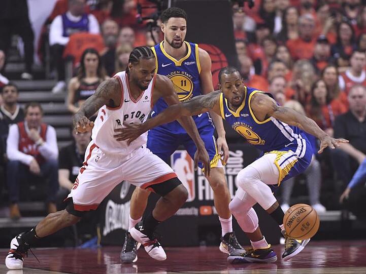 Raptors-Star Kawhi Leonard (l) im Kampf um den Ball mit Andre Iguodala (r) von den Warriors.