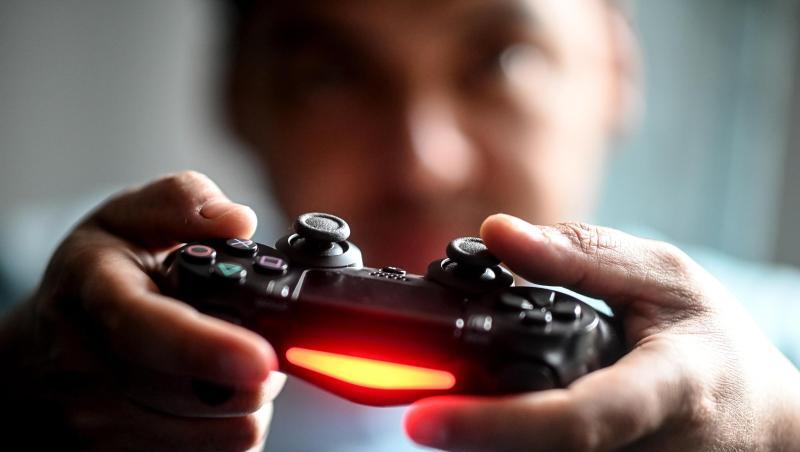 Ein junger Mann spielt mit der Spielekonsole Playstation vor dem Fernseher. Ein junger Mann spielt mit der Spielekonsole Playstation vor dem Fernseher.