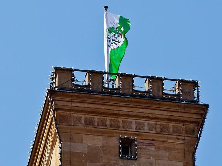 Auf dem Turm vom Rathaus in Fürth (Mittelfranken) weht die Fahne der SpVgg Greuther Fürth. Foto: Daniel Karmann/Archivbild