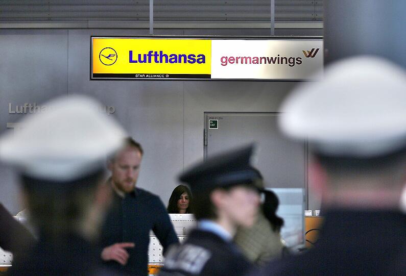 Polizisten stehen am Flughafen Düsseldorf im Terminal und warten auf Angehörige der Passagiere.
