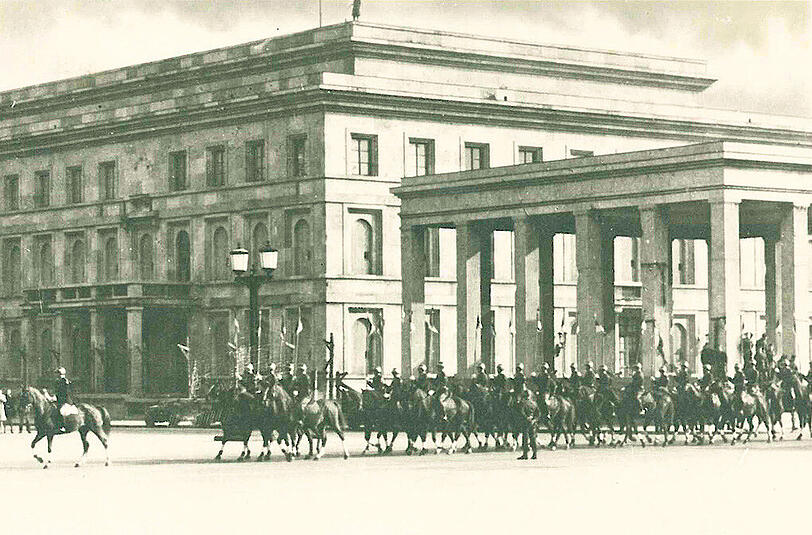 Die Truppenparade zieht zu Pferde an einem der NS-Ehrentempel vorbei.