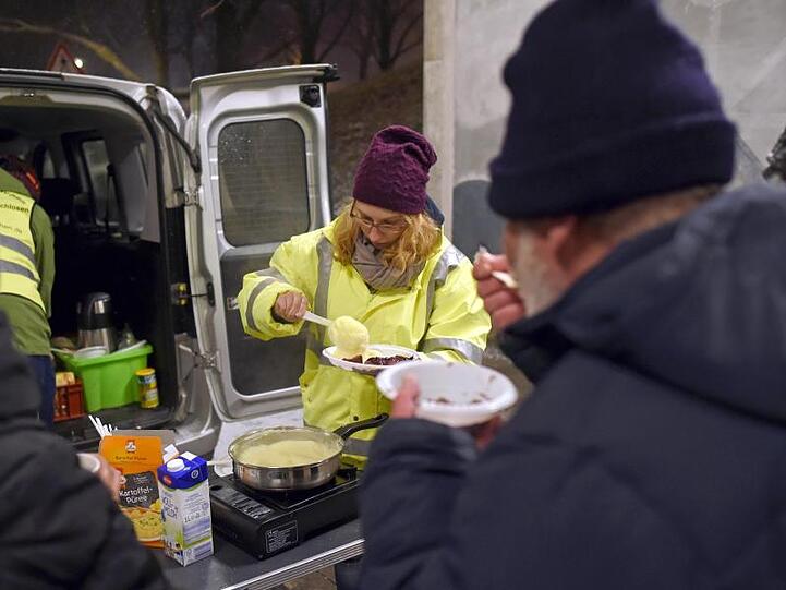 Freiwillige des Vereins "Kältebus München" verteilen Essen an Obdachlose. Foto: Andreas Gebert/Archiv