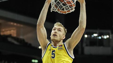 Albas Niels Giffey legt den Ball in den Korb und hängt daran. Foto: Andreas Gora/dpa/Archivbild