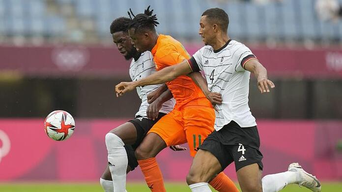 Deutschlands Felix Uduokhai (r) und Jordan Torunarigha (l) nehmen Christian Kouame in die Zange.
