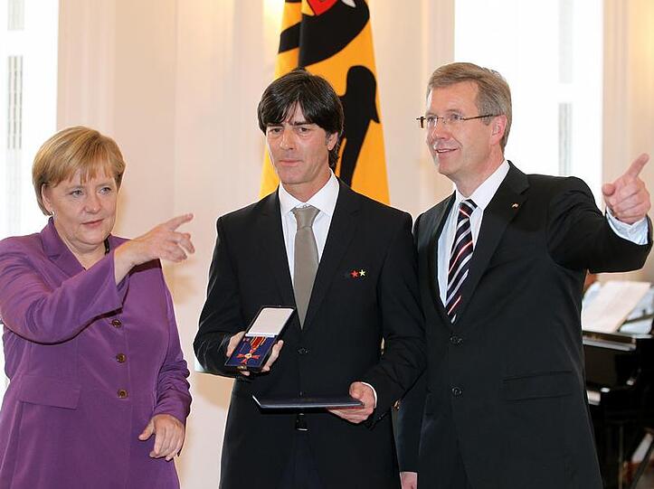 Großer Bahnhof für Joachim Löw: Kanzlerin Angela Merkel und der Bundespräsident Joachim Wulff ehren den Bundestrainer.