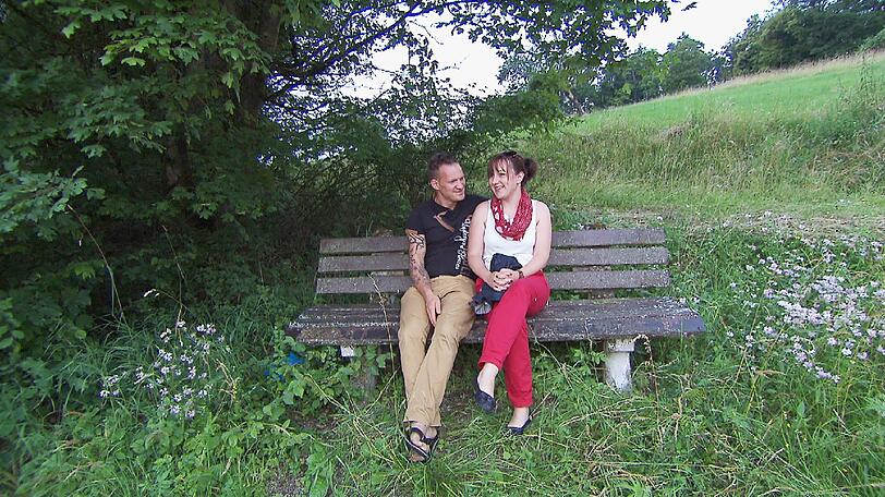 Nach einem Besuch auf der Kuhweide, genießen Jörg und Vanessa auf einer Bank die schöne Aussicht.