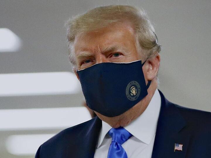 Donald Trump mit einem Stoff-Mundschutz, auf dem das Präsidenten-Siegel abgebildet ist.