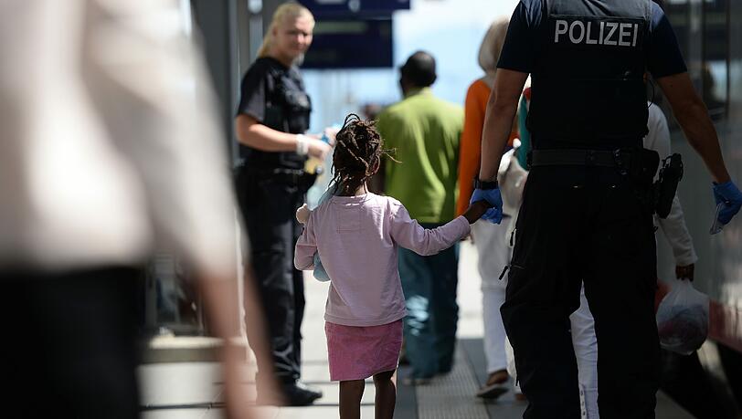 Kleine Geste, große Wirkung: Ein Polizist nimmt ein Flüchtlingsmädchen an die Hand. Kleine Geste, große Wirkung: Ein Polizist nimmt ein Flüchtlingsmädchen an die Hand.