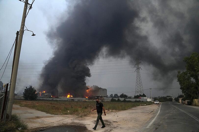 Afidnes: Rauch steigt auf über eine Autoverwertungsanlage, die von den Flammen eines Waldbrandes in Brand geraten ist.