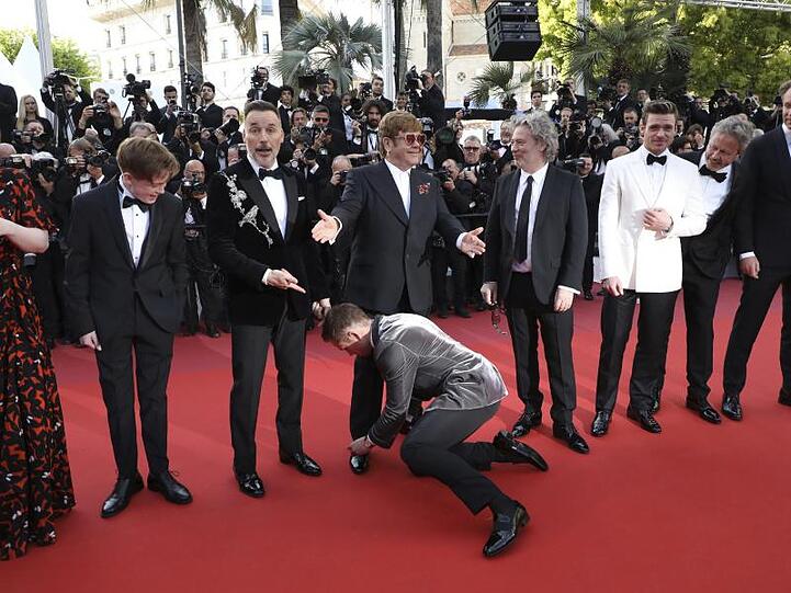 Fürsorglich: Taron Egerton bindet Elton John die Schnürsenkel.