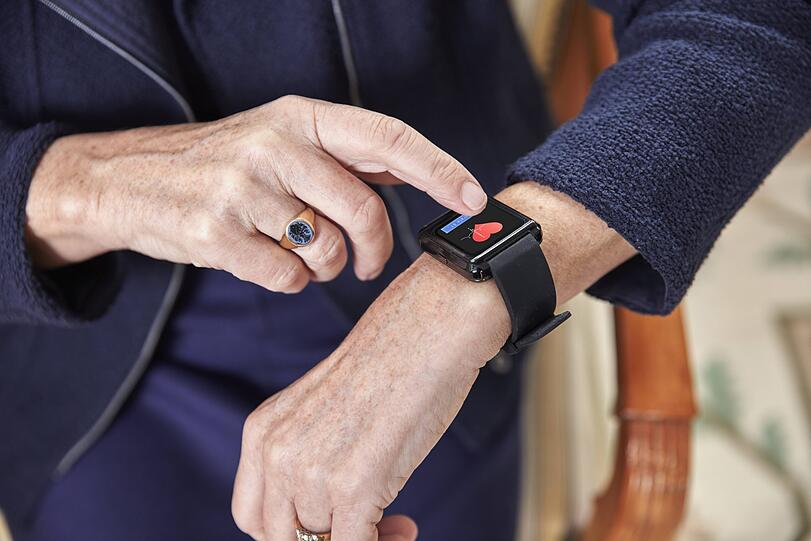 Eine ältere Dame überprüft auf ihrer Smartwatch Daten. (Symbolbild)