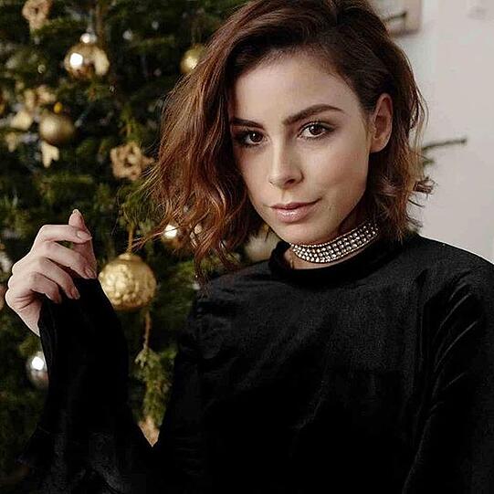 Lena Meyer-Landrut posiert vor ihrem Weihnachtsbaum.